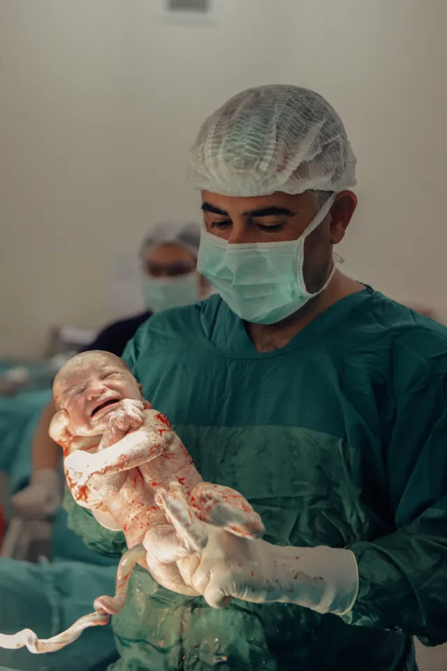 Op. Dr. Hayri Aksüt yenidoğan bebeğe bakarken