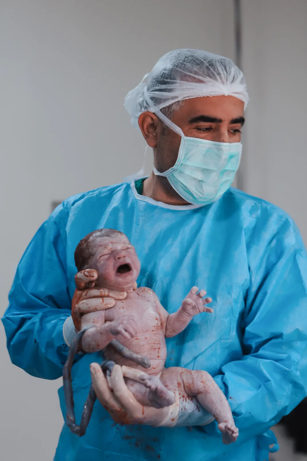 Op. Dr. Hayri Aksüt sezaryenle doğan bebeği kucağında tutuyor