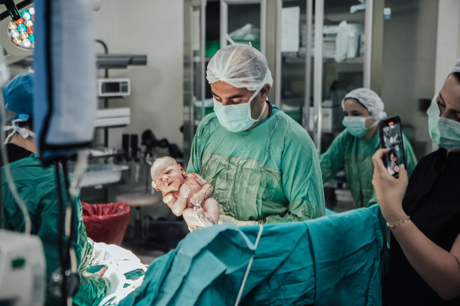 Yenidoğanı kucağında tutan Op. Dr. Hayri Aksüt ve ekip