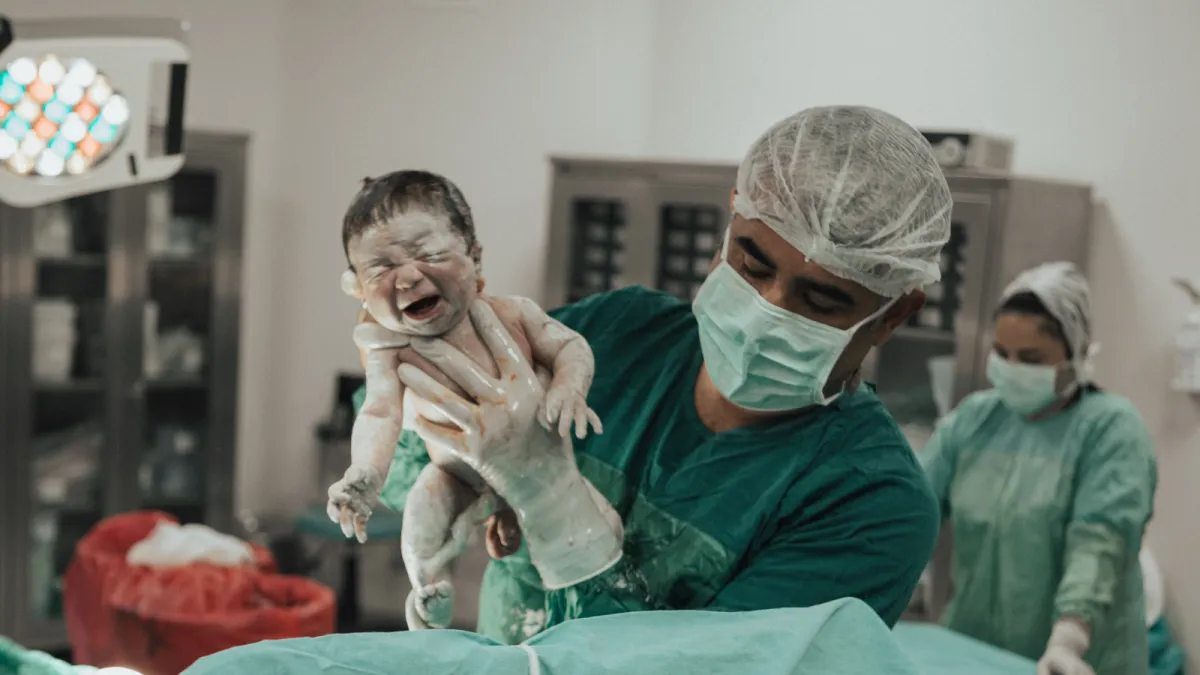 Op. Dr. Hayri Aksüt doğumda yenidoğanı kaldırırken